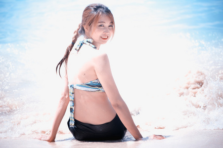 亚洲美丽的年轻女子在比基尼在海滩上