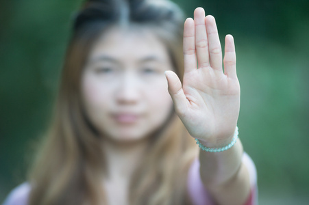 亚洲妇女显示停止手势，焦点手