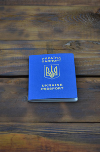 照片的乌克兰外国护照, 躺在一个黑暗的木质表面。介绍乌克兰公民免签证旅行的概念