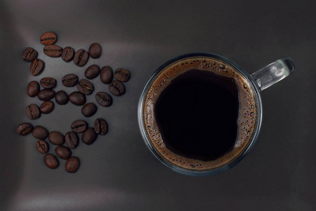 杯黑咖啡的咖啡豆的棕色板上