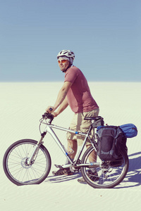 骑着自行车在沙漠中旅行的人