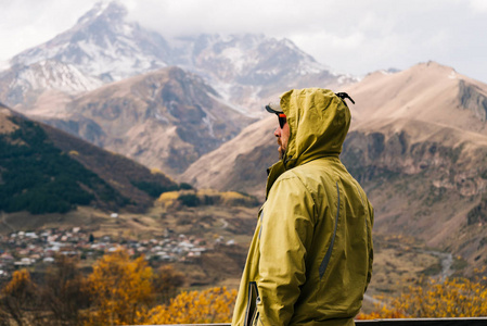 穿着保暖夹克的男士旅行穿过群山, 享受大自然