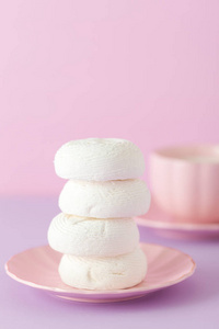 紫色柔和的水平横幅白色的西风甜点在粉红色的盘子和杯咖啡与牛奶