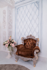 Versaillese 风格的棕色扶手椅。椅子旁边有花的花瓶