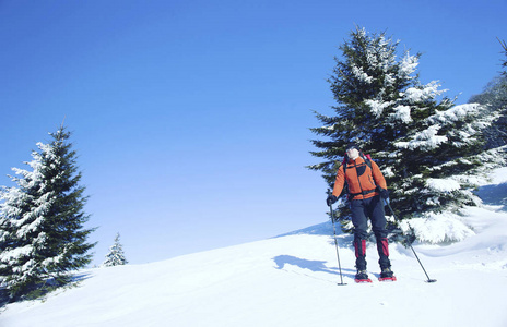 冬季徒步旅行。在山里徒步旅行带着背包和帐篷雪的冬天