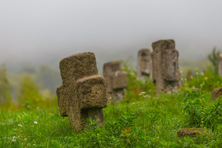 公墓的石制十字架在雾中图片