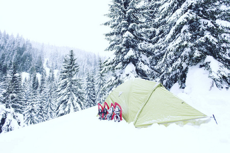 冬季徒步旅行。在山里徒步旅行带着背包和帐篷雪的冬天