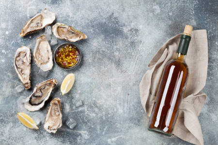 石桌上的新鲜牡蛎和白葡萄酒。具有文本空间的顶部视图