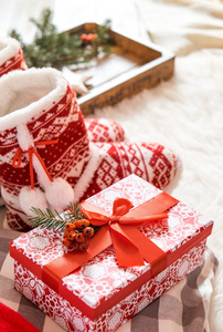 明亮房子地板上的礼品盒和圣诞拖鞋。