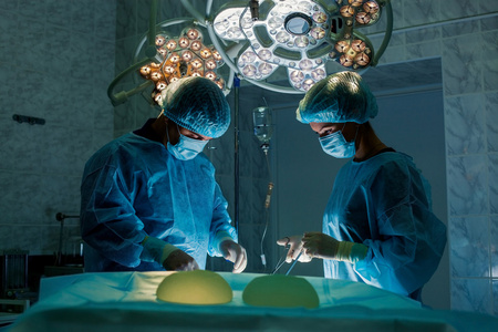 外科医生团队合作监测病人的外科手术室。隆胸