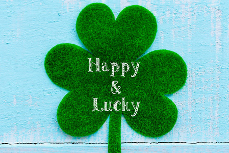 快乐 St 帕特里克天消息和许多绿纸三叶草叶子在柔和的白色和蓝色木桌背景纹理