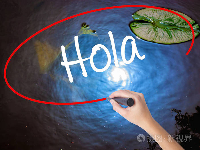 女人的手写作 hola (你好西班牙语) 标记在 tra