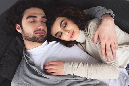 年轻夫妇在家里睡觉和拥抱的高角度视图