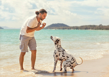 狗在热带海滩上的男人