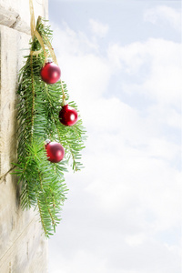 冷杉的枝条与木墙上，明亮的红色圣诞小玩意