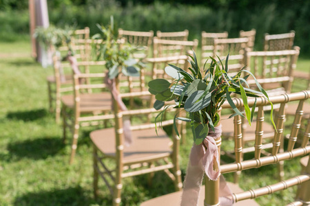 用花装饰的木椅, 在松树林的婚礼区内。