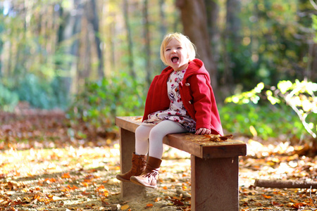 快乐的小女孩玩在秋天的树林