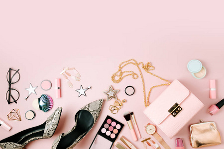 平躺的女性时尚饰品, 彩妆产品和手袋的粉彩色彩背景。美与时尚理念
