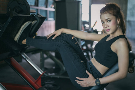 年轻的健身亚洲女人用机电缆交叉锻炼