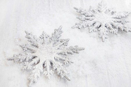 两个银闪闪发亮雪花饰品在雪中