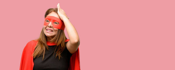 中年超级英雄女子身穿红面具和海角惊恐不安地表达焦虑和惊恐的姿态, 不知所措