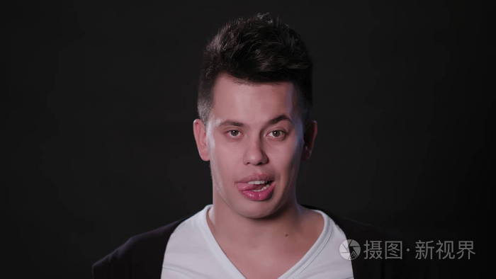 男子咬他的舌头对黑色背景