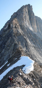 山导游带领两个男性客户到一个岩石脊和开始高高山山顶