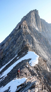 山导游带领两个男性客户到一个岩石脊和开始高高山山顶