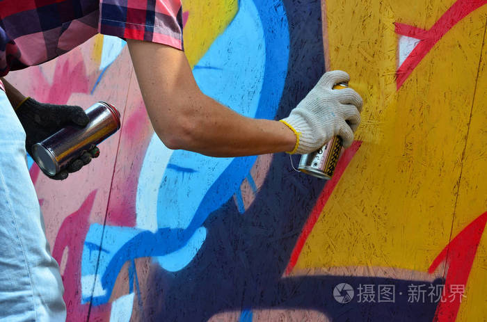 一只手用一种喷雾可以得出新的涂鸦墙上.