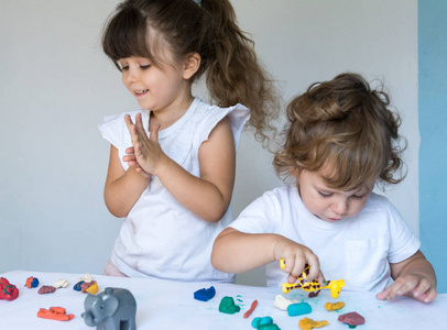 孩子们玩五颜六色的造型粘土和玩具在幼儿园前或幼儿园。学前儿童玩具开发