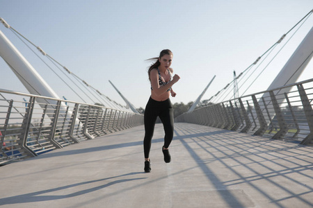 活跃的妇女赛跑者跨桥梁, 户外奔跑, 体育和健康生活方式概念的慢跑
