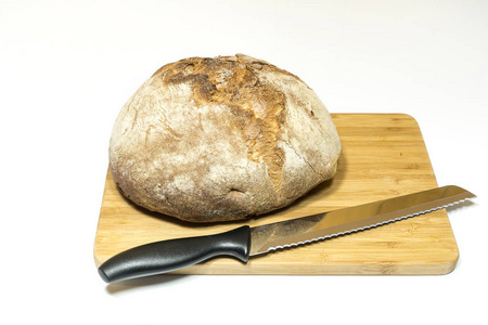 用小刀在木制的切板上一条面包