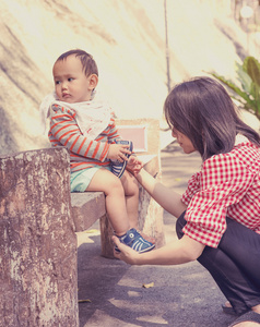 亚洲母亲穿鞋的男婴在室外公园