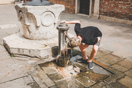 男孩从街头泵，威尼斯，夏天 2015年喝水