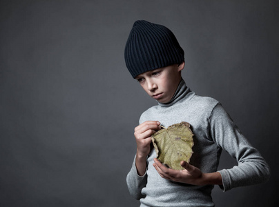 伤心的少年，在灰色的背景上的肖像