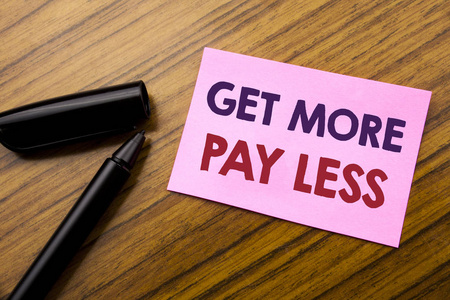 字, 写作得到更多的薪水少。商业概念的预算口号的概念写在粘纸条红纸, 木制背景与钢笔。注意贴在桌子上