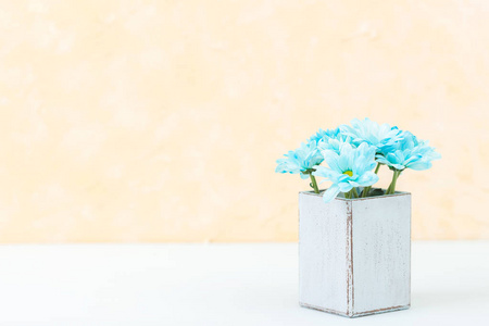 柔和的黄色垂直横幅与美丽的花束新鲜的蓝色菊花在复古破旧别致的花瓶。Copyscape 地区