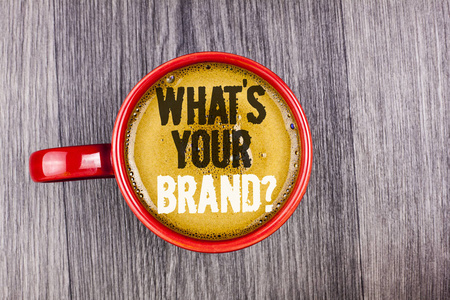 写笔记, 显示你的品牌问题。商业照片展示询问关于您的公司制造商或模型写在咖啡在红色杯子在灰色木背景。顶部视图