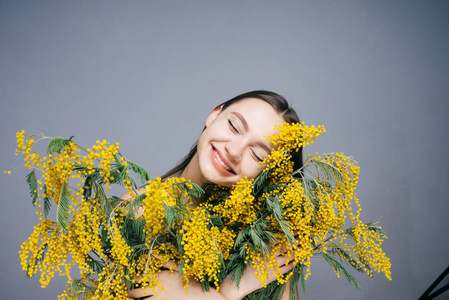 在手捧着一束黄色花朵的快乐年轻女子