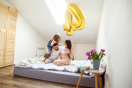 在家中快乐的家庭在她的房间庆祝她女儿的第四岁生日