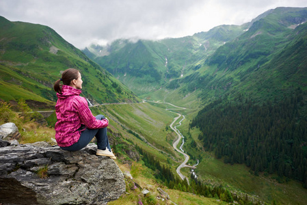 拍摄的女性旅行者微笑着看着离开坐在岩石顶部欣赏校正山风光 copyspace 景观自然环境友好旅游旅行