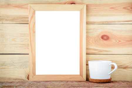 木制背景上的空框和白杯