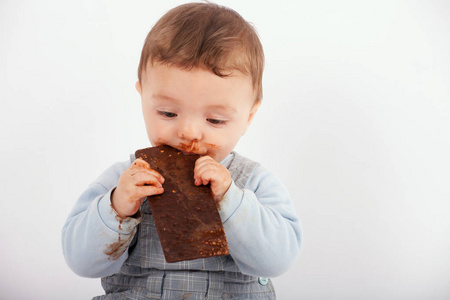 可爱的宝宝吃一盘巧克力。Wh 一个孤立的工作室