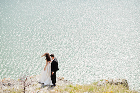 婚礼情侣在惊险的风景与岩石和湖