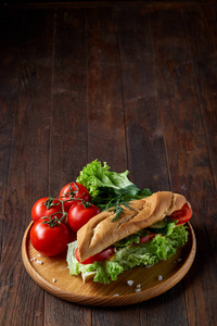 新鲜的三明治与生菜, 西红柿和奶酪服务于木质板材的木质背景, 选择性聚焦