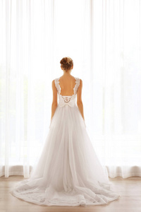 站在窗口附近美丽的婚纱礼服的新娘