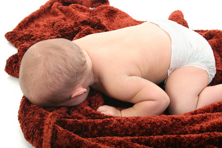 婴儿穿着尿布躺在毯子上图片