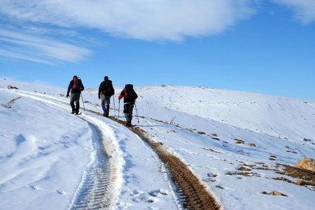 在阳光明媚的冬日在雪地上跋涉