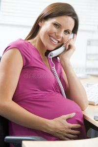 上班孕妇用电话微笑