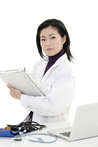 亚洲女医生或护士，在办公桌上拿着医疗垫工作